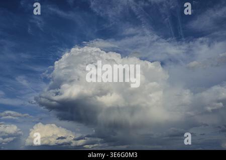 Large clouds are visible in the sky in the afternoon. They are constantly changing and creating different shapes. The view is wide and shows the blue Stock Photo