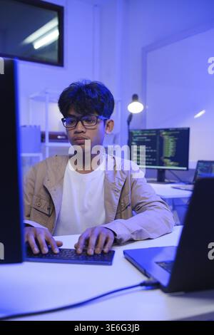 Male Software Engineer Writing Code on Desktop Computer with Multiple Screens Setup. Data center programmer managing large datasets used in AI trainin Stock Photo