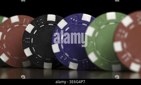 Poker chips stand in a row on a black background, a Domino effect. Playing poker chips are on the table, a symbol of casino Stock Photo