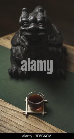 A tranquil tea set beautifully decorated with a guardian lion statue and a delicate and elegant teacup Stock Photo
