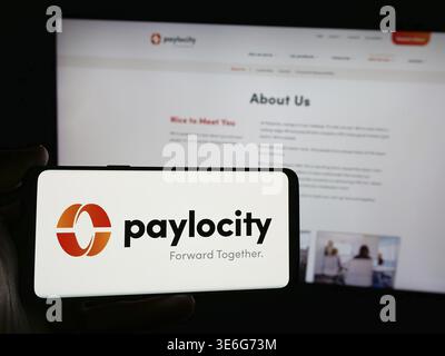 Stuttgart, Germany - 10-01-2024: Person holding smartphone with logo of software company Paylocity Holding Corporation on screen in front of website. Stock Photo