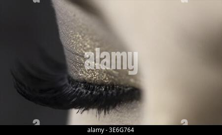 Close-up of beautiful female eye with long black lashes. Action. Extreme length of eyelashes, super black and swirled on macro photography of charming Stock Photo