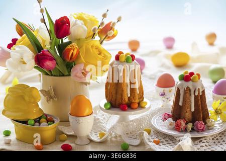 Easter table setting with spring flowers, cakes and easter eggs Stock Photo