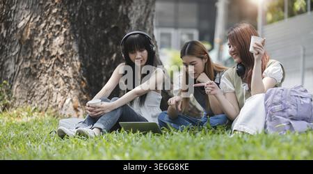 Group Of Young Asian Students Collaborating Outdoors at University. Teamwork and Knowledge Sharing. Asian Students Engaged in Collaborative Learning O Stock Photo