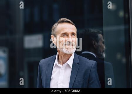 Bearded man wearing suit standing at office building outdoors Stock Photo