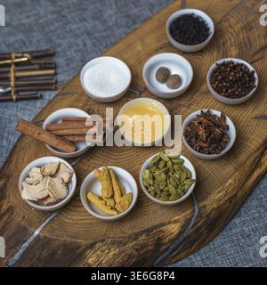A vibrant and colorful display of diverse spices and fresh ingredients beautifully arranged on a wooden platter Stock Photo