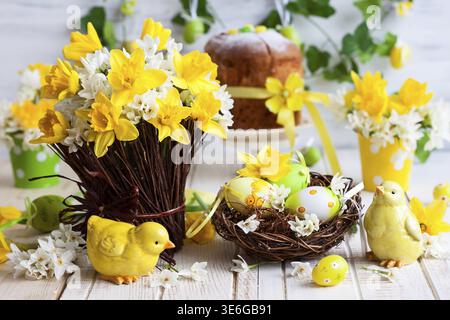 Easter table decoration with fresh daffodils, chick and eggs Stock Photo