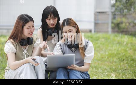 Group Of Young Asian Students Collaborating Outdoors at University. Teamwork and Knowledge Sharing. Asian Students Engaged in Collaborative Learning O Stock Photo