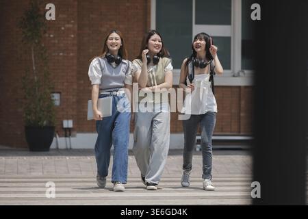 Group of happy students walking along the corridor at college Stock Photo