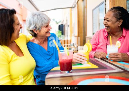 Multiracial senior friends having fun outside bar restaurant while drinking healthy smoothies Stock Photo