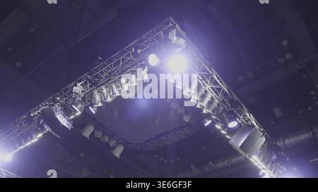 A view from above of the ceiling of a concert stage with red and white spotlights. Spotlights above the stage. Light theatrical spotlights above the s Stock Photo