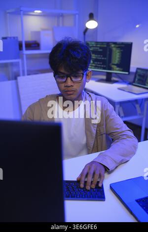 Male Software Engineer Writing Code on Desktop Computer with Multiple Screens Setup. Data center programmer managing large datasets used in AI trainin Stock Photo
