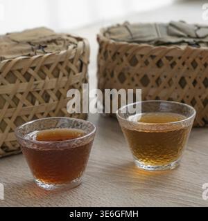 A beautiful and aesthetic display showcasing two elegant tea cups with various types of tea beside woven baskets Stock Photo