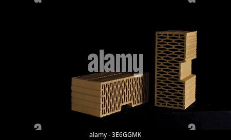 Wall construction materials, small pile of ceramic blocks isolated on black background. Red new perforated bricks Stock Photo