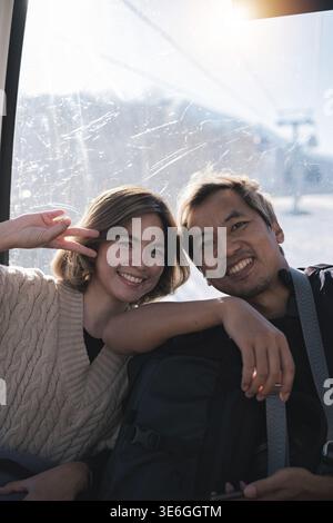 Smiling couple posing inside cable car. Concept of joy and travel Stock Photo