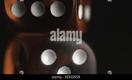 Red dices on black background. Red dice standing on each other, macro on black background Stock Photo