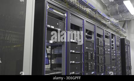 Storage servers are located in the server room of the data center. Back of the server installed in the server room. Many cables are connected to a pow Stock Photo