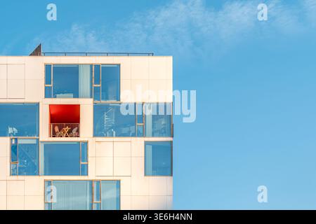 Modern Apartment Building Facade with Red Balcony, Minimalist Architecture, Contemporary Residential Stock Photo