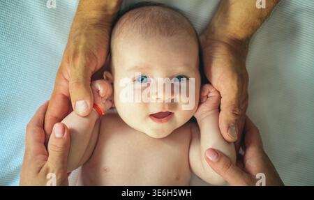 Newborn baby in parents hands. Infant baby lying safely while parents support. Baby care concept and family bonding. Newborn with loving parental Stock Photo
