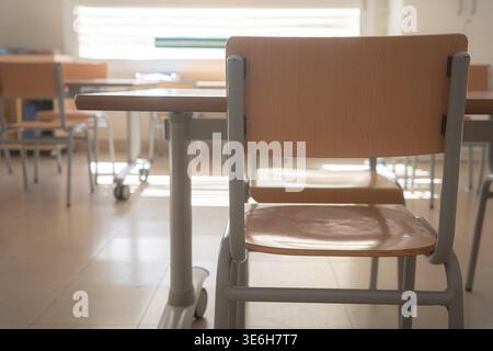 Empty classroom with desks and chairs in daylight Stock Photo