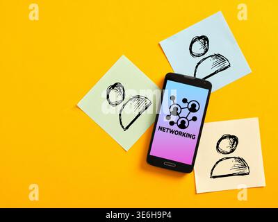 Networking concept displayed on smartphone screen and symbolized by contacts drawn on sticky notes placed on yellow background Stock Photo