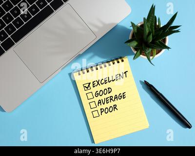 Excellent service evaluation checked on notepad with laptop, pen and plant on blue background, concept of customer satisfaction Stock Photo