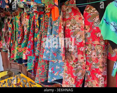 Vibrant traditional Chinese quilted floral jackets known as Dong Bei Da Hua on display in Dali Market, Yunnan, China. Stock Photo
