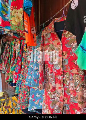 Vibrant traditional Chinese quilted floral jackets known as Dong Bei Da Hua on display in Dali Market, Yunnan, China. Stock Photo