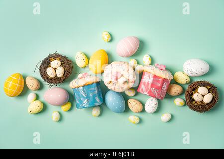 Happy Easter composition for easter design. Elegant Easter eggs, Easter cakes and nests on mint background. Flat lay, top view, copy space. Stock Photo