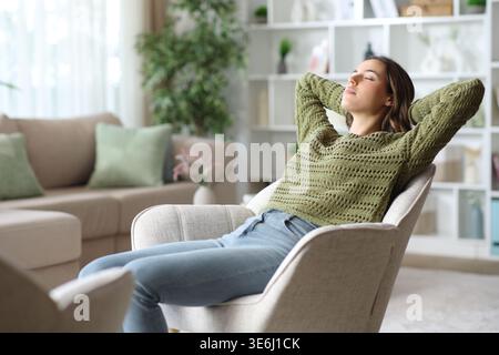 Woman resting and relaxing at home sitting on armchair in the living room Stock Photo