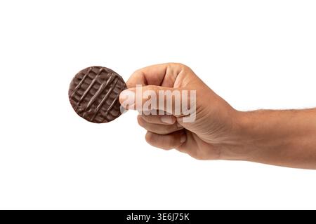 Male hand holding dark chocolate coated digestive biscuit isolated on white. Stock Photo