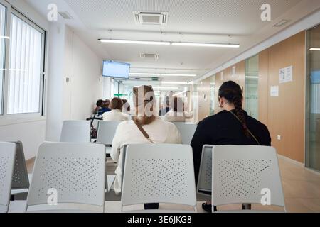 Seville, Spain; April 06 2026: Patients waiting in Seville public health center reception area seating Stock Photo