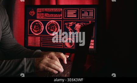 Gamer plays on keyboard, than gets up from computer he was playing on. Dimly lit scene with red graphics on monitor. Concept of computer gamer and com Stock Photo