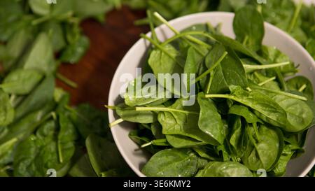 Fresh spinach leaves in bowl green background healthy food concept Stock Photo