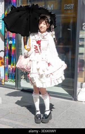 dress japanese street style A woman dressed in Lolita fashion poses on Takeshita Street. Takeshita in Harajuku, Tokyo is a narrow, pedestrian shopping street known for its colorful youth fashion, quirky boutiques, and street female tokyo street fashion