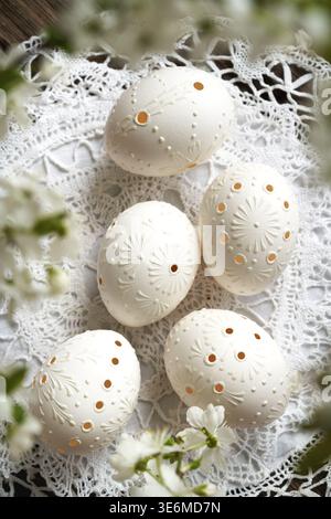 White Easter eggs decorated with wax, with cherry blossoms in spring Stock Photo