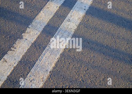 Double white dividing strip on the asphalt of the road. The asphalted road with two continuous white strips. The highway with a white marking Stock Photo
