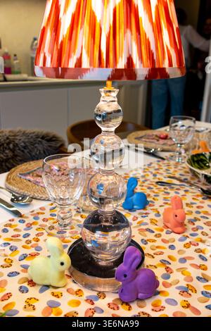 A table laid for an Easter lunch party with Easter Eggs and small bunny rabbits Stock Photo