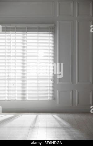 Sun shining through window blinds in light room Stock Photo
