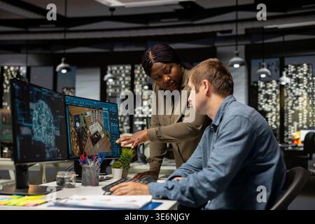 Diverse team of engineers using artificial intelligence to design a floor plan, working together with neural networks and computer aided apartment layout on architectural software. Stock Photo