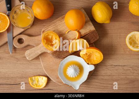 Composition with ripe citrus fruits and ceramic juicer on wooden background Stock Photo
