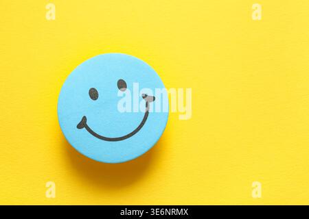 Sticky note with smiley face on yellow background Stock Photo