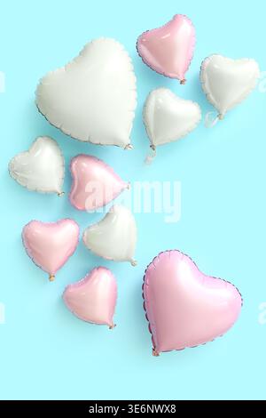 Many heart shaped air balloons on blue background. Valentine's day celebration Stock Photo