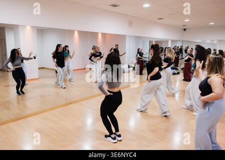 Group of dancers rehearsing choreography in a studio with mirrors Stock Photo