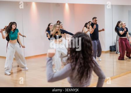 Diverse group of dancers training in studio with instructor Stock Photo