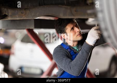 Service station man employee works in repair box, department Stock Photo