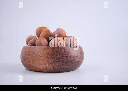 Hazelnuts in a wooden bowl on a white background Stock Photo