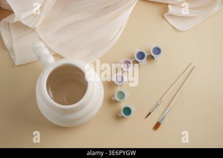 Art supplies and a pot on a table for a craft project Stock Photo