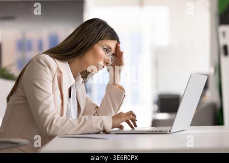 Frustrated businesswoman reading bad news on laptop Stock Photo