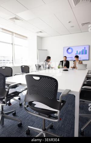 Businesspeople sit at conference table in office boardroom, planning strategy, make decisions, engage in executive discussion at corporate business me Stock Photo